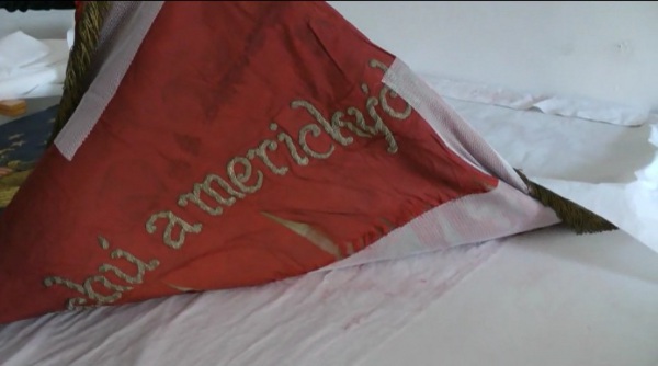 Nápis na praporu je dosud velmi dobře čitelný. Látka pod ním se však vlivem času postupně rozpadá. Nápis na praporu je dosud velmi dobře čitelný. Látka pod ním se však vlivem času postupně rozpadá.