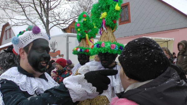 Dva slamění a kominík začerňující tváře pro štěstí foto: dva slamění sledují kominíka, který začerňuje přihlížejícím pro štěstí tváře