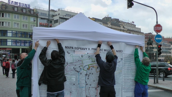 Vyvěšování dopravního schématu Pražské muzejní noci na inforrmační stan Vyvěšování dopravního schématu Pražské muzejní noci na inforrmační stan