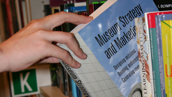 Knihovna obsahuje převážně cizojazyčné publikace fotografie ruky vytahující knihu z police