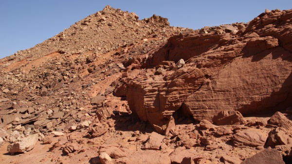 Jak nasvědčuje charakteristické zvrstvení patrné na bloku vpravo v popředí, vznikaly rudé pískovce z materiálu přineseného cenomanskou řekou v oblasti její delty. Tyto pískovce přístupné na alžírsko-marockém pomezí obsahují množství pozůstatků obratlovců včetně dinosaurů. Jak nasvědčuje charakteristické zvrstvení patrné na bloku vpravo v popředí, vznikaly rudé pískovce z materiálu přineseného cenomanskou řekou v oblasti její delty. Tyto pískovce přístupné na alžírsko-marockém pomezí obsahují množství pozůstatků obratlovců včetně dinosaurů.