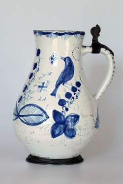 Džbánek fajánsový, habánská keramika, hruškovitého tvaru, s kobaltovým dekorem, pták, květiny, ouško s cínovou montáží, bez víčka, konec 17. století. Zdroj: Národní muzeum