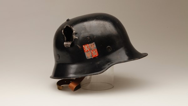 Přilba barikádníka z Pražského povstání, který zemřel 10. 5. 1945, na následky střelného zranění na hlavě které utrpěl v boji na barikádě (zdroj: Národní muzeum)