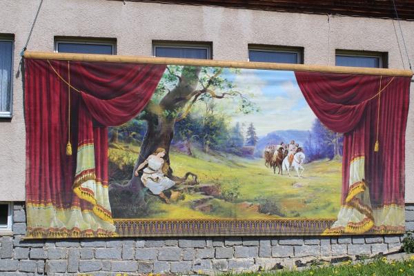 Opona je tak rozměrná, že pro zdokumentování musela být provizorně zavěšena na fasádu roudnického stavení. Zdroj: Obec Jestřabí v Krkonoších Fotografie. Opona je tak rozměrná, že pro zdokumentování musela být provizorně zavěšena na fasádu roudnického stavení. Zdroj: Národní muzeum