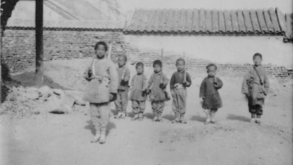 Skupina dětí si hraje na vojáky s dřevěnými puškami. Čína, Peking, 1901. Zdroj: Národní muzeum Fotografie. Skupina dětí si hraje na vojáky s dřevěnými puškami. Čína, Peking, 1901. Zdroj: Národní muzeum