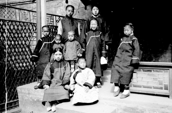 Skupina dětí mandžuských šlechticů na verandě domu. Čína, Peking, 1901. Zdroj: Národní muzeum Fotografie. Skupina dětí mandžuských šlechticů na verandě domu. Čína, Peking, 1901. Zdroj: Národní muzeum