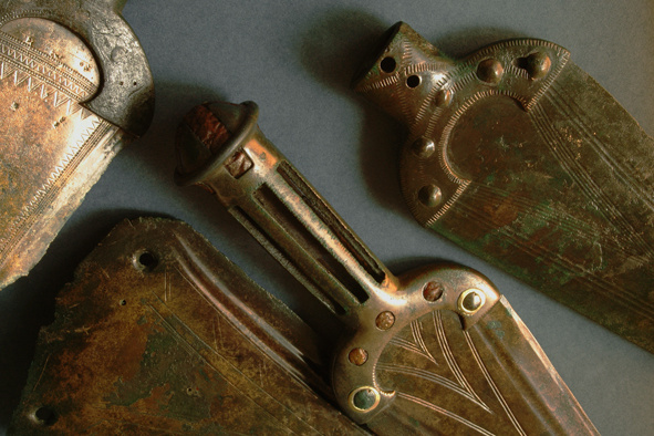 Depot bronzových dýk nalezený mezi obcemi Praha-Suchdol a Únětice, v pásu buližníkových skalek zvaných Kozí Hřbety, patří mezi nejvýznamnější středoevropské objevy starší doby bronzové. Lité bronzové předměty, uložené do země asi v 17. stol. př. n. l., jsou dekorovány precizní geometrickou rytou výzdobou, objeví se i jantarové a zlaté aplikace. Foto L. Káchová. Fotografie. Depot bronzových dýk nalezený mezi obcemi Praha-Suchdol a Únětice, v pásu buližníkových skalek zvaných Kozí Hřbety, patří mezi nejvýznamnější středoevropské objevy starší doby bronzové. Lité bronzové předměty, uložené do země asi v 17. stol. př. n. l., jsou dekorovány precizní geometrickou rytou výzdobou, objeví se i jantarové a zlaté aplikace. Foto L. Káchová.