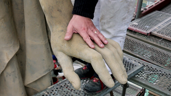 Právě restaurovaná sousoší patří do čtveřice nejmohutnějších sochařských děl na budově. Fotografie - ruka na soše