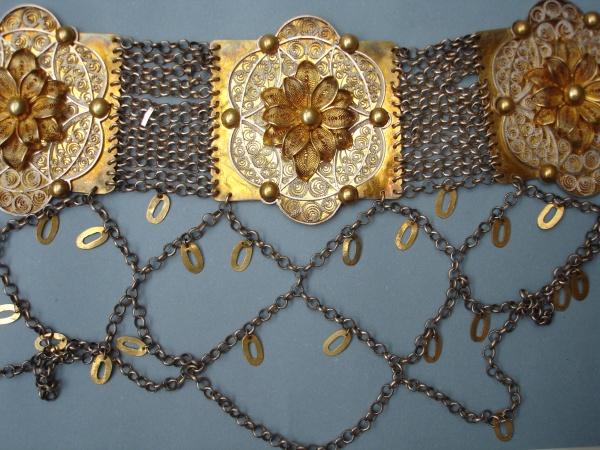 Pás stříbrný filigránový, částečně pozlacený, unikátní filigránová práce. Pás má puncovní značku „EW“ – zlatník Emil Wotke, který působil přímo v Těšíně (1855–1924). V 8568, ošetřeno. Zlatník Emil Wotke vynikal zejména svými filigránovými pásy, lancušky a háčky. Těšínské Slezsko, 2. polovina 19. století. Etnografické oddělení Národního muzea, H4-103843. Zdroj: Monika Tauberová 2012 Pás stříbrný filigránový, částečně pozlacený, unikátní filigránová práce. Pás má puncovní značku „EW“ – zlatník Emil Wotke, který působil přímo v Těšíně (1855–1924). V 8568, ošetřeno. Zlatník Emil Wotke vynikal zejména svými filigránovými pásy, lancušky a háčky. Těšínské Slezsko, 2. polovina 19. století. Etnografické oddělení Národního muzea, H4-103843. Zdroj: Monika Tauberová 2012