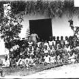 Děti z Basilejské misie s misionářkou a místní vychovatelkou před vchodem do školy. Ghana (Zlaté pobřeží), 1885-1888