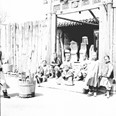 Skupina dětí před obchodem s rakvemi. Čína, Peking, 1901
