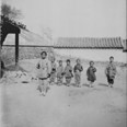 Skupina dětí si hraje na vojáky s dřevěnými puškami. Čína, Peking, 1901